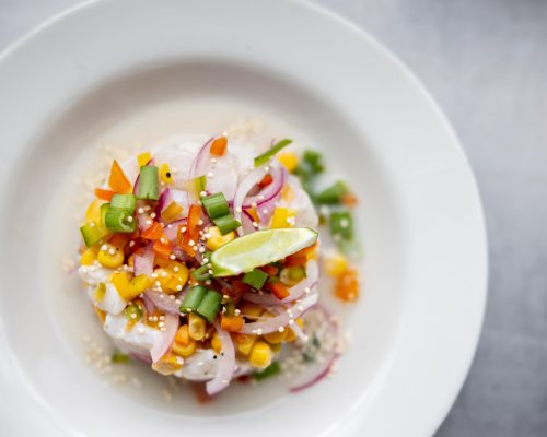 Clos-up on a plate of ceviche served at a restaurant - food and drinks cocnepts